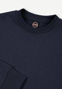 Donkerblauwe sweatshirt met geribbelde ronde hals en manchetten. Heeft een soepele textuur, casual ontwerp en een Colmar merklabel.