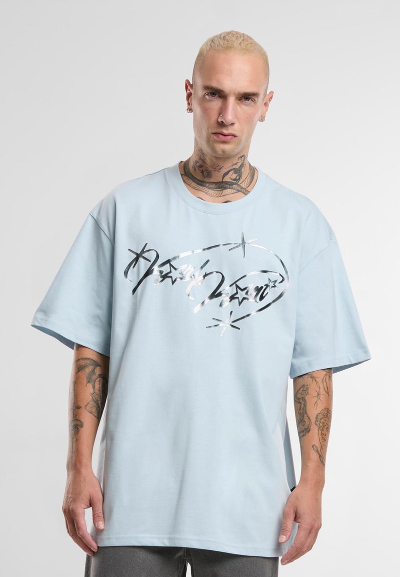 Valge sinine suur suurusega t-särk, mis on valmistatud puuvillast, esiküljel läikiva musta ja hõbedase graafika kujundusega, millel on tähe aktsendid.