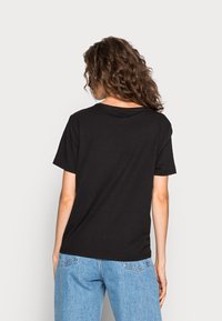 Svart kortärmad t-shirt i bomull med avspänd passform och rund halsringning. Synliga sömmar, inga mönster eller accentuerande detaljer.