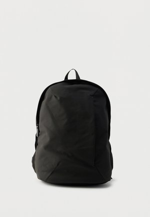 Sac à dos noir avec une finition mate et lisse. Doté d'une poignée supérieure, de bretelles rembourrées et de poches latérales zippées.