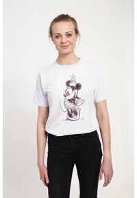 T-shirt bianco in cotone con una grafica disegnata di un topo dei cartoni animati con pois e un fiore, abbinato a jeans neri.