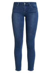 Hubené džíny v tmavě modrém denimu. Mají klasický pětivreckový design, poutka na opasek a zapínání na knoflík. Hladká textura s mírným elastanem.