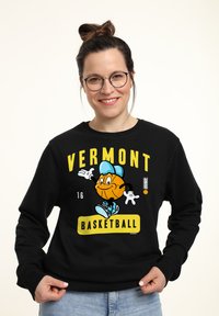 Felpa nera con un personaggio di basket in stile cartone animato giallo e blu, con la scritta "VERMONT BASKETBALL", colletto rotondo e maniche lunghe.