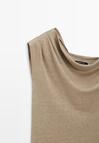 Ärmelloses beiges Stricktop mit gepolsterten Schultern und rundem Ausschnitt, Marke Massimo Dutti.