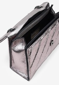 Bolso de mano metálico rosa con un acabado texturizado, patrón de costura diagonal y forro negro. Cuenta con un cierre de imán y una correa de cadena.