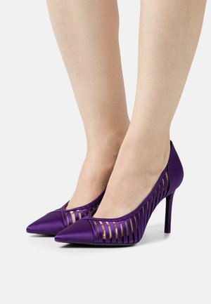 Purple satin high-heeled shoes with cut-out design on the sides and pointed toe. Features a stiletto heel. Smooth texture.
