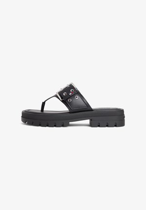Black chunky sole sandal with a thick strap, silver buckle, and toe post, featuring a small red, white, and blue logo on the side.