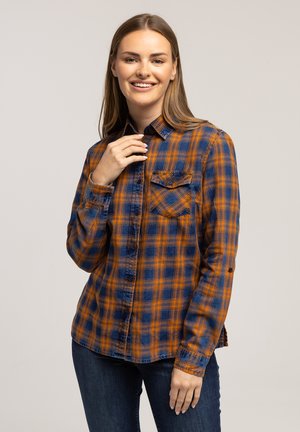 Niebieska i pomarańczowa koszula w kratę z długimi rękawami, z kieszonką na piersi i zaokrąglonym zakończeniem. Materiał wydaje się miękki z delikatnym połyskiem.