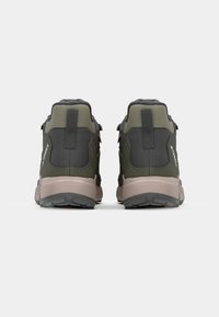 Chaussures de randonnée vert olive et noires avec un tissu texturé, un talon renforcé et une semelle gris clair. Présente un logo et des sangles de traction à l'arrière.
