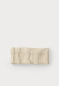Beige ribbed fabric headband with a knot detail in the center. Soft texture, stretchy fit, and smooth interior lining.