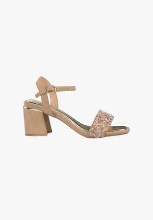 Beige Wildleder-Sandalette mit Blockabsatz, einstellbarem Knöchelriemen und dekorativem, mit Strass besetztem Vorderband. Glänzende Innensohle.