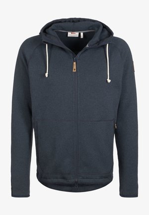 Veste zippée à capuche bleu foncé avec poches avant et cordons blancs, présentée sur un fond blanc uni.