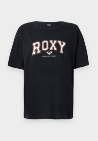 Must värvi puuvillane T-särk lühikeste varrukatega. Esiküljel on julge valge ja punane "ROXY" tekst, allpool "PARADISE FOUND". Regulaarne lõige ja lihtne ümar kaelus.