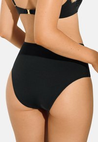Bas de bikini noir taille haute en matériau lisse, avec une large ceinture et un design épuré comprenant des détails de couture minimaux.