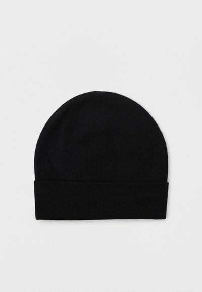 Μαύρο πλεκτό σκουφί με διπλό γείσο, τοποθετημένο επίπεδο σε λευκό φόντο.