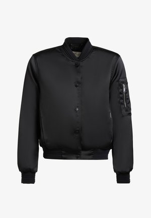 Fekete szatén bomberdzseki bordázott gallérral, mandzsettákkal és alsó szegéllyel, elülső patentgombokkal és cipzáras zsebbel a bal ujján.