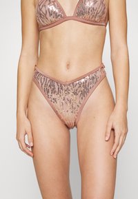 Biquíni rosa adornado com um top triangular com lantejoulas e detalhes de estampado animal. A parte de baixo apresenta um design de corte alto com acentos laterais.