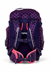 Purple backpack with pink scallop pattern, adjustable straps, multiple pockets, and a textured finish. Includes a vibrant pink zipper accent.