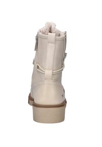 Beige enkellaarzen met een gladde lederen buitenkant, nepbontvoering, twee zijritsen en een vlakke rubberen zool. Subtiele stikdetails.