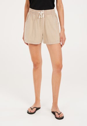Shorts beige avec une taille élastique et un cordon de serrage, dotés de poches latérales et d'une coupe décontractée. Le matériau a un aspect texturé.