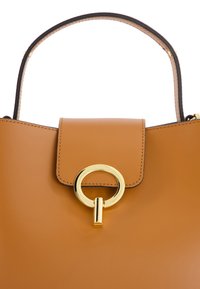 Tarnfarbenes Lederhandtasche mit strukturiertem Design, ausgestattet mit einem goldenen, runden Verschluss und einem oberen Griff mit kontrastierenden Nähten.