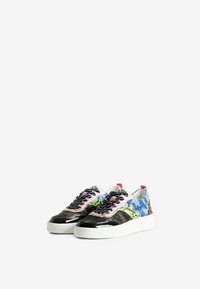 Baskets multicolores avec une surface texturée et à motifs, présentant des lacets noirs, une semelle blanche et des accents roses au niveau du talon.