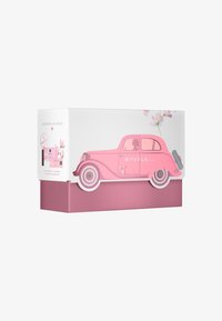 Emballage en forme de voiture rose avec des accents blancs, arborant un motif floral, une finition brillante et une base rose texturée. Contient un parfum de voiture et des lingettes nettoyantes.