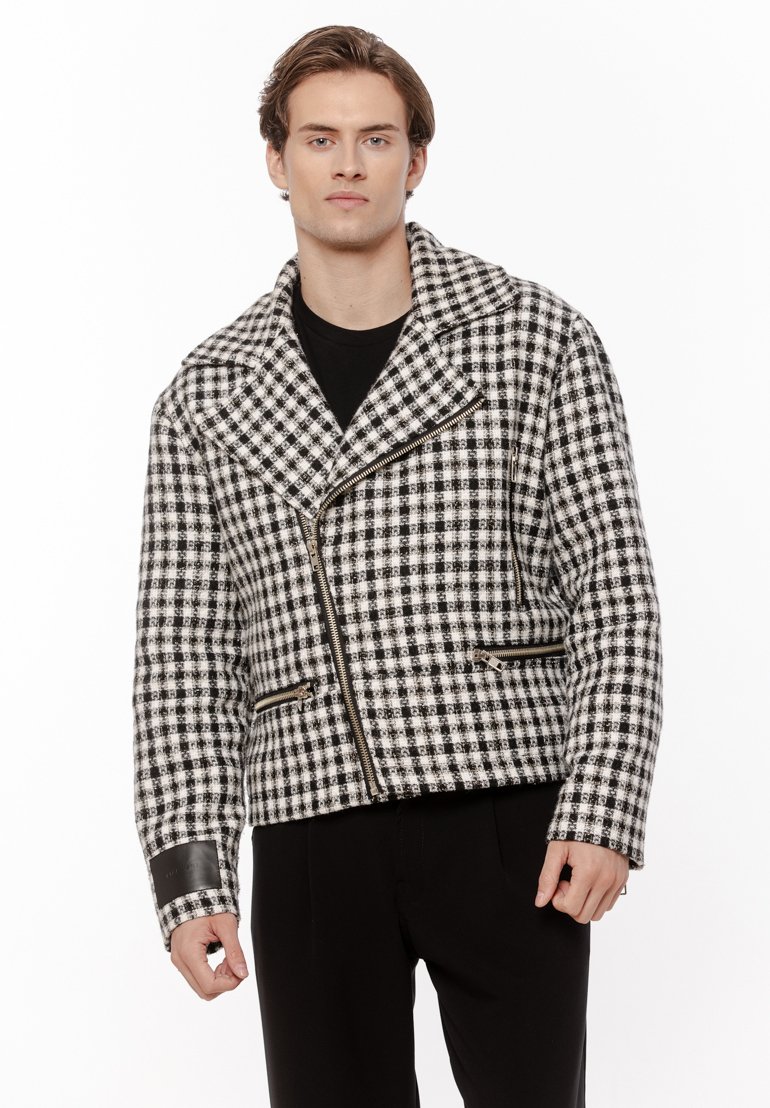 Czarna i biała w kratę kurtka z wełny z klapami, zamkiem błyskawicznym z przodu oraz dwoma kieszeniami na zamek. Skórzane akcenty na mankietach.