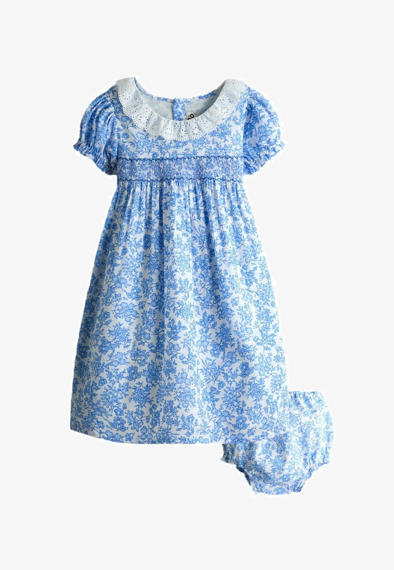 Blau-weißes Baby-Kleid mit Blumenmuster, Puffärmeln, geraffter Brustpartie, Lochspitzenkragen und passenden Höschen vor weißem Hintergrund.