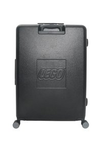 Svart hårdskalväska med texturerad yta, präglad LEGO-logotyp, övre handtag och fyra små hjul för rörlighet.