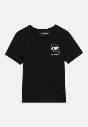 Czarna koszulka z krótkim rękawem z małą białą grafiką osoby noszącej okulary przeciwsłoneczne oraz tekstem "KARL LAGERFELD" na piersi.
