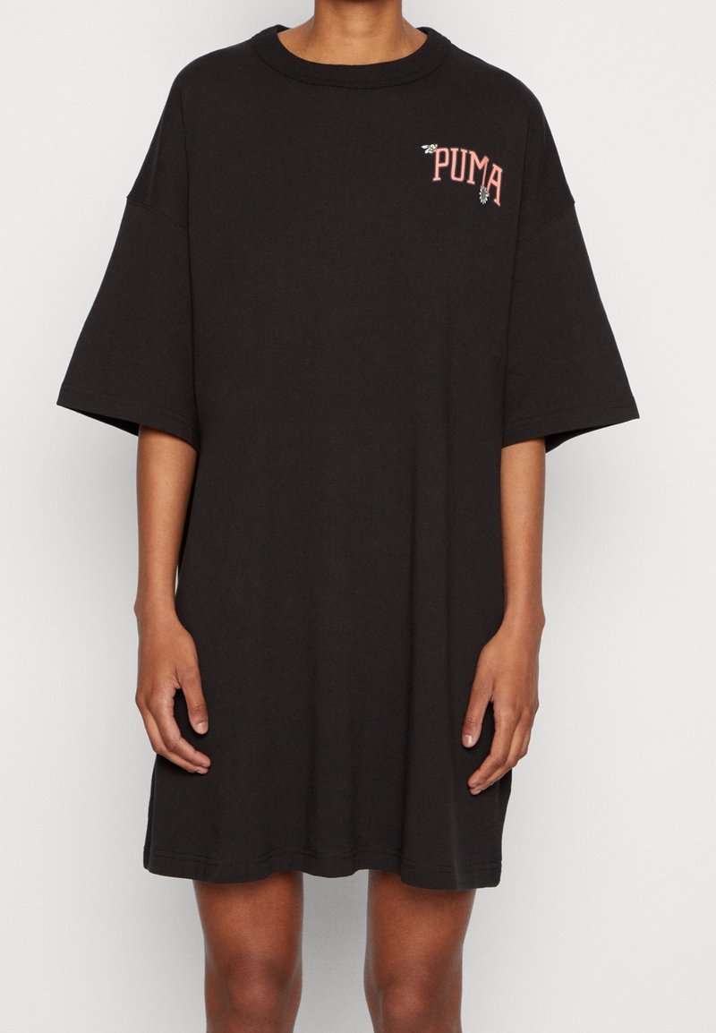 Czarna, oversize sukienka t-shirt z bawełny z okrągłym dekoltem. Posiada małe, różowe logo Puma na lewej piersi oraz krótkie rękawy.