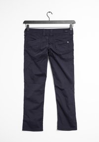 Námorně modré kalhoty visící na černém ramínku. Mezi jejich vlastnosti patří dvě zadní kapsy, mírný lesk a rovný střih s hladkou texturou.