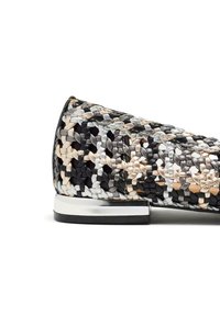 Scarpa slip-on intrecciata con un motivo nero, beige e argento, punta rotonda e un piccolo dettaglio metallico sul tacco.