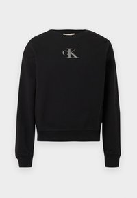 Czarna bluza wykonana z miękkiego materiału, z okrągłym dekoltem i długimi rękawami. Na środku klatki piersiowej znajduje się srebrne logo „cK”.