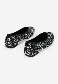 Bailarinas negras cubiertas de lentejuelas plateadas, con puntera redonda y un tacón bajo y plano. El forro de tela suave proporciona comodidad.