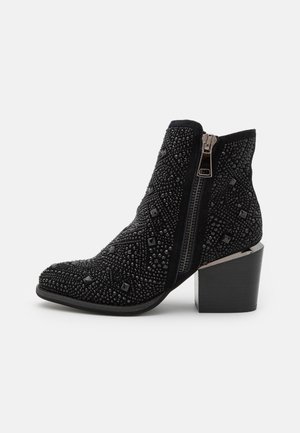 Schwarze Knöchelstiefel mit einer strukturierten, perlenbesetzten Oberfläche, seitlichem Reißverschluss und blockartigem Absatz; verfügen über geometrische Muster und quadratische Akzente.