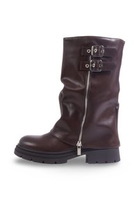 Botte en cuir marron avec un design structuré, fermeture éclair et deux boucles sur le côté. Caractéristiques d'une semelle en caoutchouc épaisse et texturée.