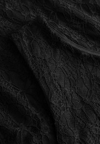 Fekete csipkeanyag, amely bonyolult virágmintákkal rendelkezik, texturált felülettel és sima szélekkel. Kiemei az anyag finom, áttetsző jellegét.