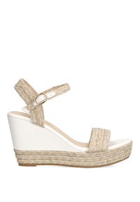 Sandalia de cuña con base de poliuretano blanco y acentos de yute trenzado. Cuenta con una correa ajustable y una textura trenzada en relieve alrededor de la suela.