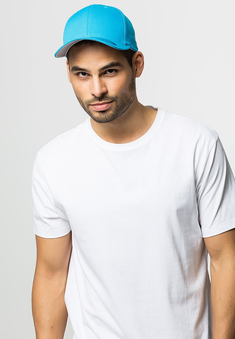 Blue cap with a curved visor, made of durable fabric. Worn with a plain white t-shirt. Visible seams and stitching details on the cap.