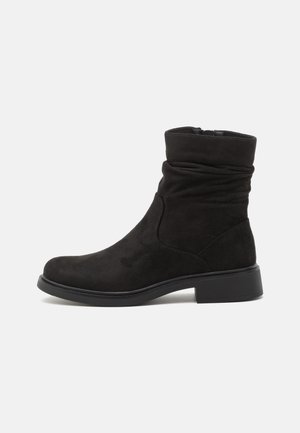 Mustad suede ankle boots laia disainiga, ümarate varvastega ja madala plokknõmbe kaaluga. Tagumise lukuga sulgemine lihtsaks pealekandmiseks.