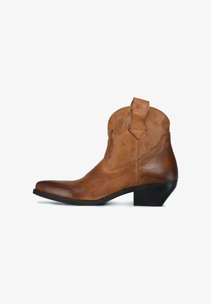 Brązowy skórzany botek za kostkę z ostro zakończonym noskiem, niskim piętkiem i przeszyciem na górze. Posiada pętelkę do zakładania oraz gładką, lekko postarzane powierzchnię.