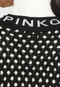 Svart stickad kofta med öppen väv och ribbad halsringning. "PINKO" är tryckt i vitt på kragen. Texturerad designdetalj.