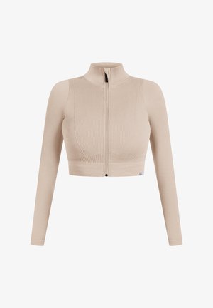 Beżowy, prążkowany crop top z wysokim kołnierzem i pełnym suwakiem z przodu, charakteryzujący się długimi rękawami i dopasowanym fasonem. Delikatne logo na dole.