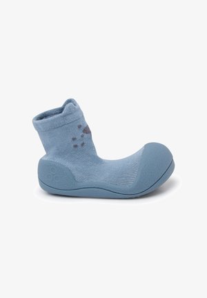 Calzado suave azul con un upper flexible similar a un calcetín y suela de goma. Presenta una punta redondeada y suela texturizada para un mejor agarre. Acabado con patrones claros.