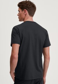 Zwarte katoenen t-shirt met korte mouwen, ronde hals en een gladde textuur. Minimalistisch ontwerp, geen zichtbare logo's of patronen.