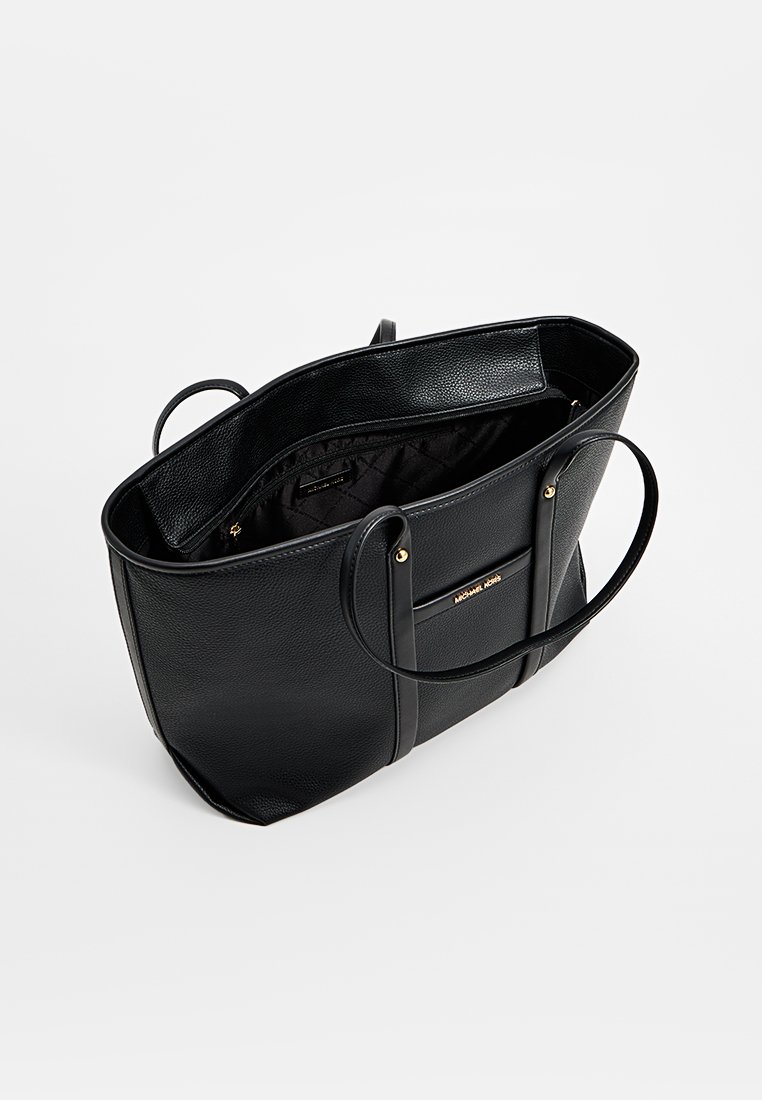 Schwarze Leder-Tote mit zwei langen Tragegriffen, strukturiertem Äußeren, offenem Oberteil und einem goldfarbenen Logo-Akzent. Das Innere hat eine dunkle Fütterung.