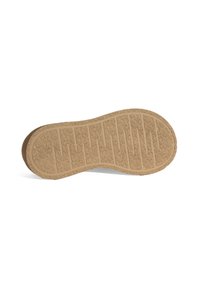 Rubberen zool van een schoen met een gestructureerd beige oppervlak, voorzien van horizontale lijnen en ribbels voor grip en tractie.