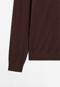 Maglione a maglia color bordeaux con maniche lunghe, polsini a coste e orlo dritto. Morbido al tatto con una finitura liscia, senza motivi visibili.